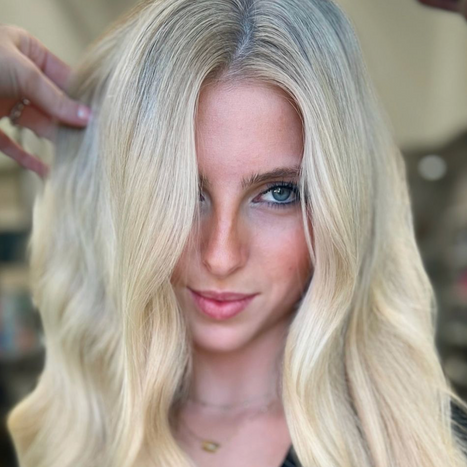 Blonde hair styling session happening.