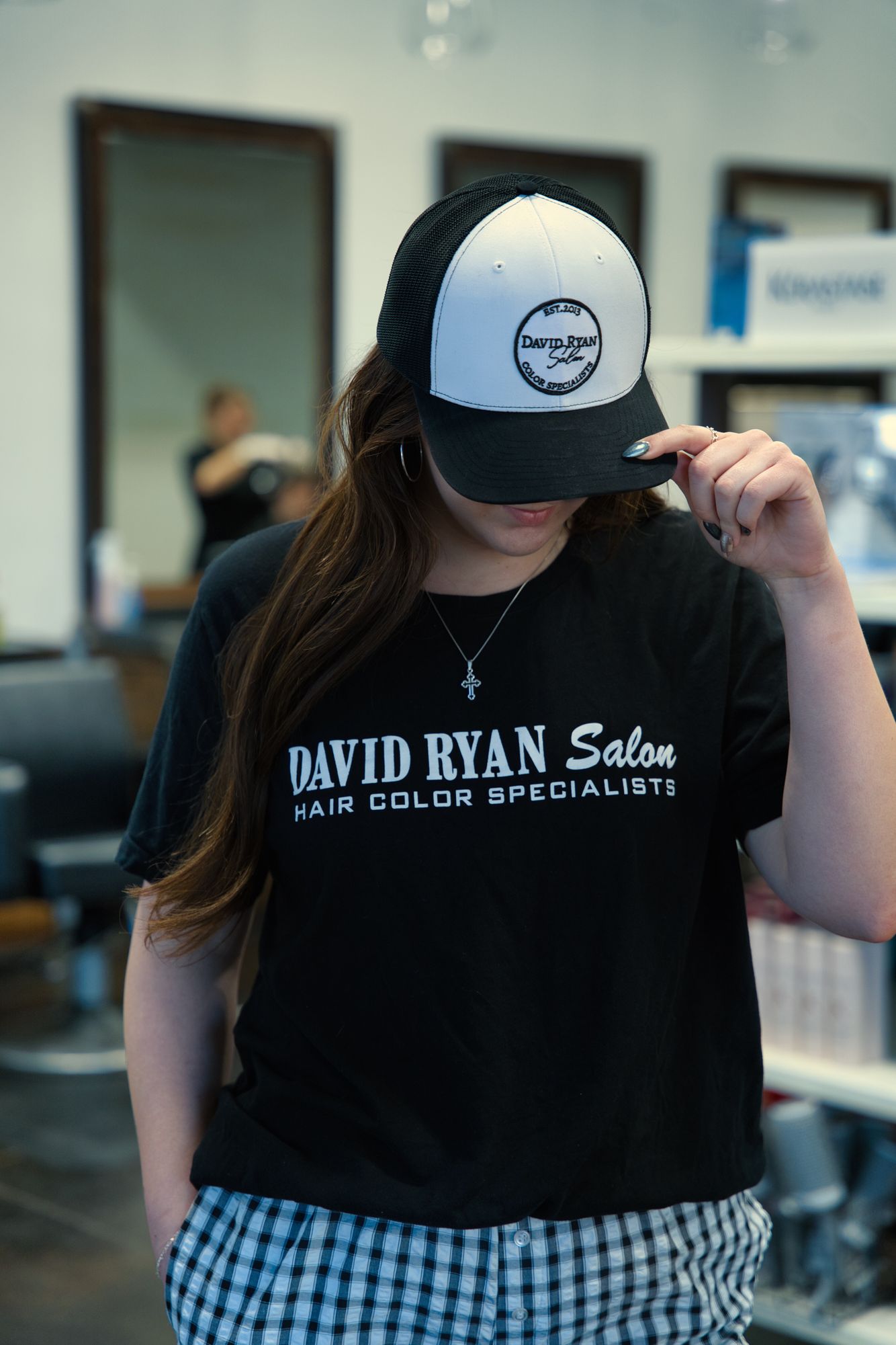 Person wearing salon branded cap.